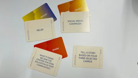 Mood, object, spark, and narrative cards laid out on a tabletop in a workshop edition.